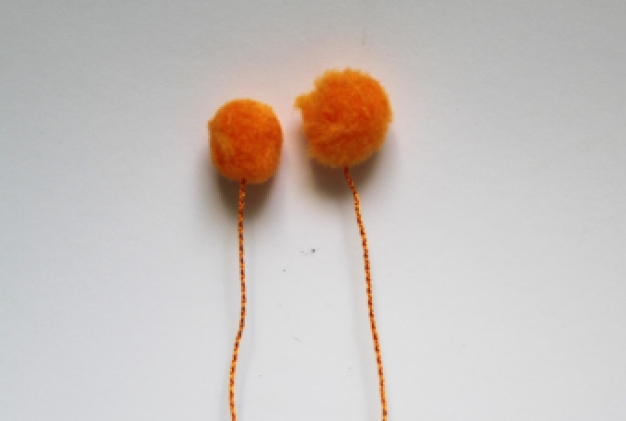 Pompom op draad oranje